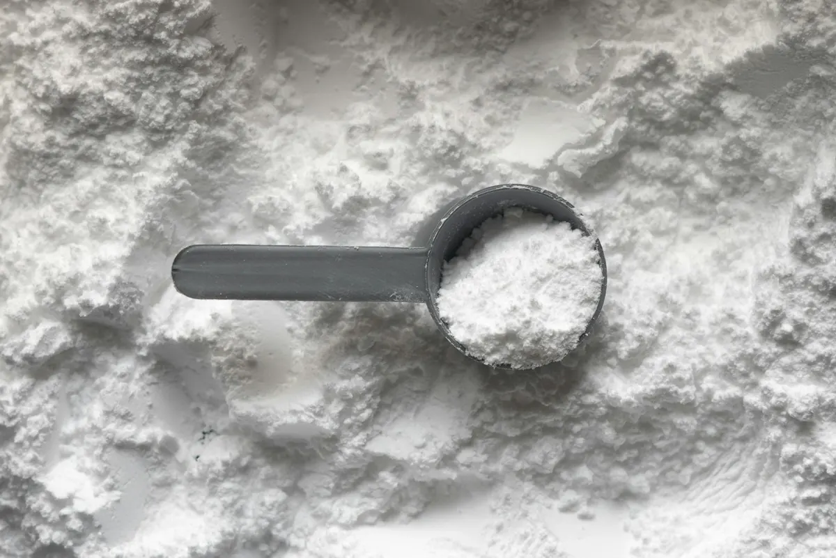 A small scoop filled with fine white powder, close up.